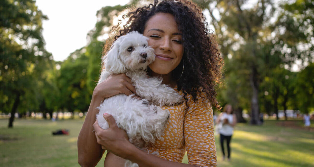 بانوی جوان در آغوش گرفتن یک سگ سفید کوچک